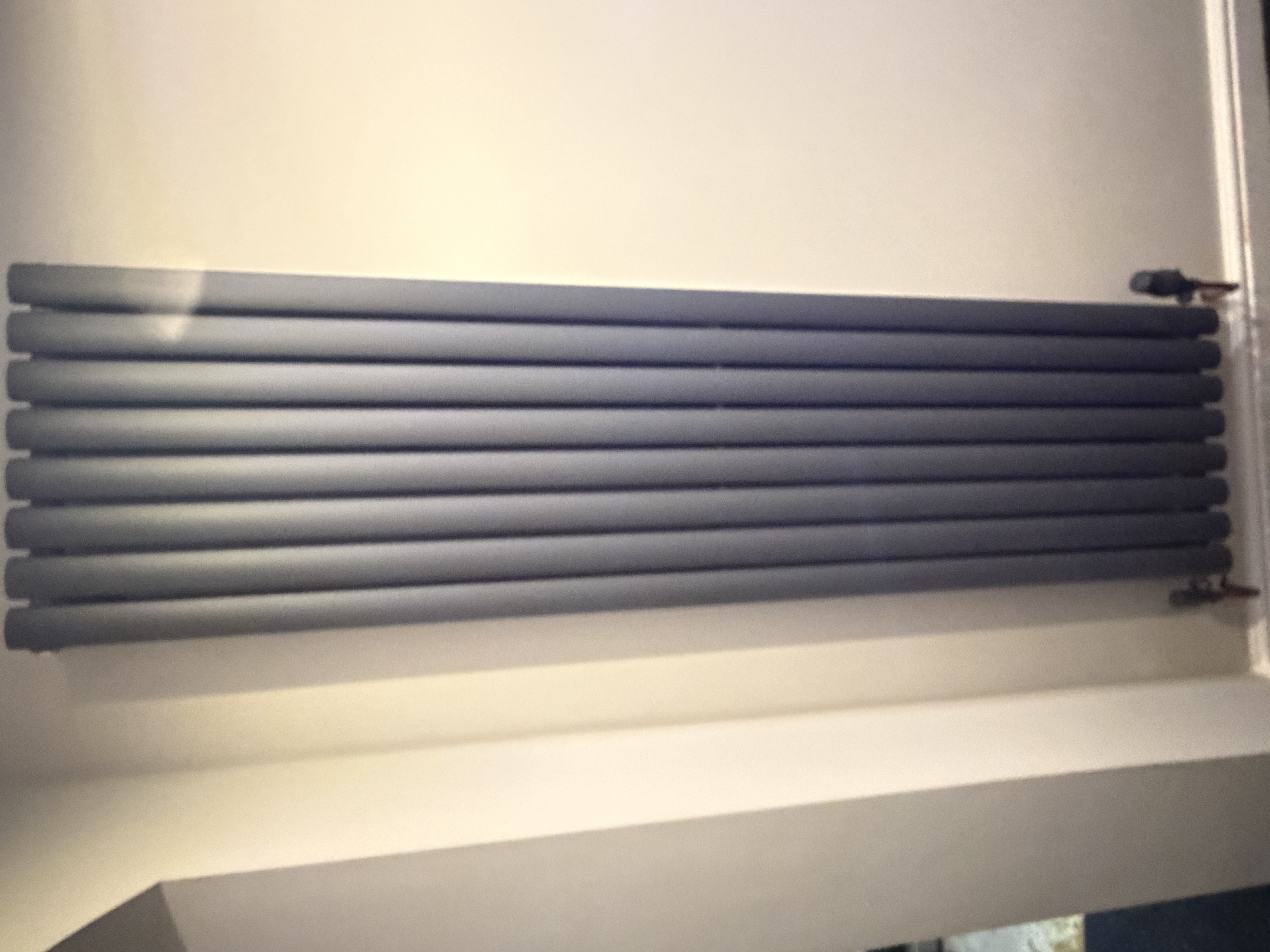 Horizontal designer radiator on white wall